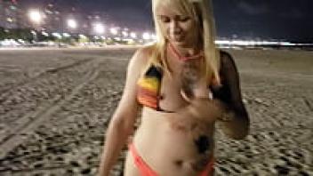 With her tits and pussy on display on the beach, the blonde Tchan