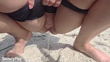 Chubby mature pussy pissed on a public beach.