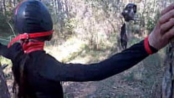 Tied up to a tree outdoors in gorgeous attire, wearing pantyhose and high ankle boots with heels.