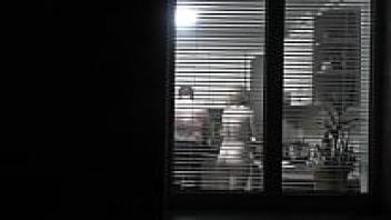 observing. Voyeur. In the evening, a pervert voyeur on the street watches out the window while her lovely, nude neighbor in the kitchen makes supper for her husband. Publicly nude. At home, naked. Family. Outside