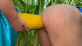 A huge dildo and an outside strap-on lover in a cornfield