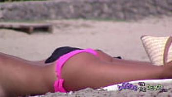 Big Fake Italian Tits and their boyfriend are wearing pink bikinis and spreading lotion on them.