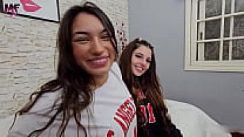 Two sexy women wearing leather boots kiss one other.