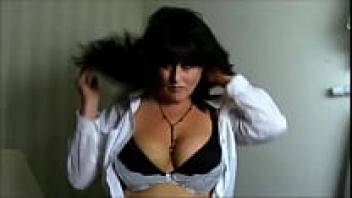 Dominique, an Arab Milf, takes off her shirt and plays with her large fake tits.