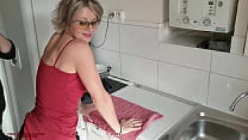In the kitchen, a 45-year-old amateur woman spreads her legs for her stepson.
