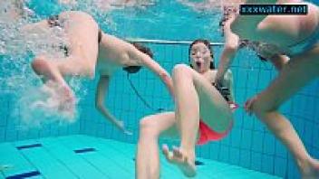 In the pool, attractive women undress.