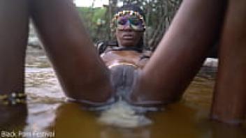 A slender, dark-skinned African beauty teasing in the water